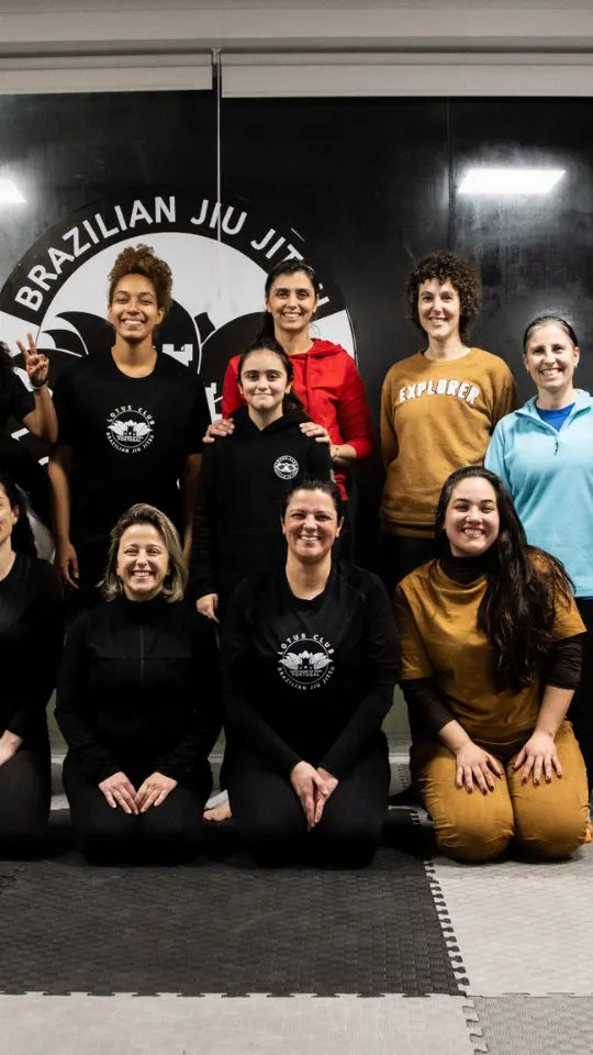 Grupo de mulheres no tatame da Lotus Club BJJ Feira depois de um seminário de defesa pessoal feminina
